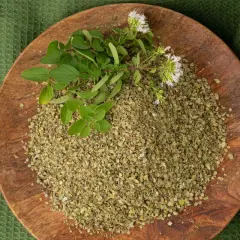Un piatto di legno con maggiorana essiccata e fresca, pronta per insaporire ogni piatto in cucina.