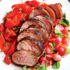 Fette di maiale, carne bianca o rossa, servite con peperoni rossi e ravanelli.