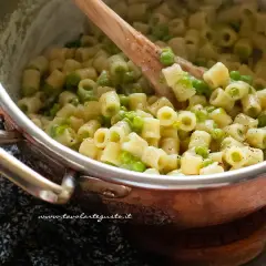 Un primo piatto cremoso di pasta e piselli, pronto per essere gustato.
