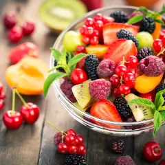 Ciotola di frutta fresca e colorata, con fragole, lamponi, ribes, more e kiwi, un'ottima scelta di frutta con meno zuccheri.