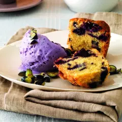 Frumina, cosa è? Un delizioso dolce con mirtilli e gelato viola, guarnito con frutta fresca.