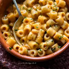Un piatto fumante di pasta e fagioli in scatola, arricchito da prezzemolo fresco, pronto per essere gustato.