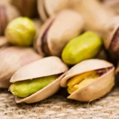 Pistacchi tostati su tela di juta. Attenzione, i pistacchi fanno ingrassare se consumati in grandi quantità!