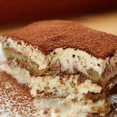 Una fetta di tiramisù, soffice e cremosa, cosparsa di cacao. Perfetta per un momento di dolcezza, anche in gravidanza.