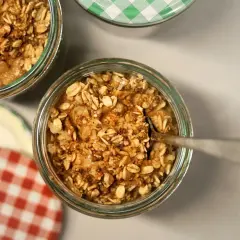 Un cucchiaino affonda in un vasetto pieno di fiocchi d'avena e cannella, pronti per essere gustati. Ecco come mangiare i fiocchi d'avena per una colazione sana.