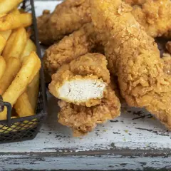Straccetti di pollo impanati croccanti e patatine fritte dorate, un classico per un pasto gustoso.