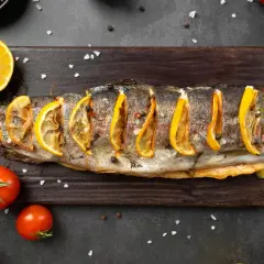 Trota al forno con fette di limone, pomodorini e sale grosso. Un piatto che ricorda i sapori del mare, ma che non appartiene ai crostacei quali sono.