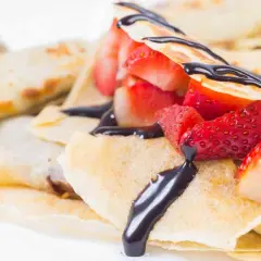 Crepes ricetta senza burro con fragole fresche e salsa al cioccolato. Deliziose e leggere, perfette per ogni occasione.