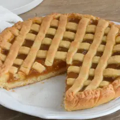 Una deliziosa crostata di marmellata, con la sua tipica griglia dorata, pronta per essere gustata.