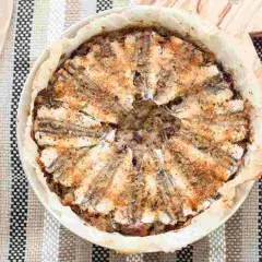 Tortiera di alici dorate e fragranti, un piatto rustico e saporito pronto per essere gustato.