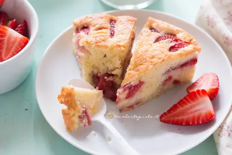 Fette di torta di fragole soffice e profumata, con fragole fresche e una cucchiaiata appena assaggiata.