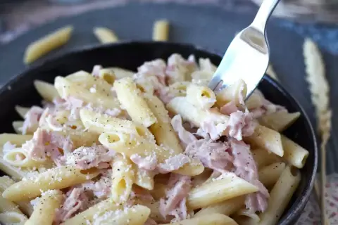 Penne cremose con prosciutto cotto e parmigiano, un piatto di pasta panna e prosciutto che invita a essere gustato.