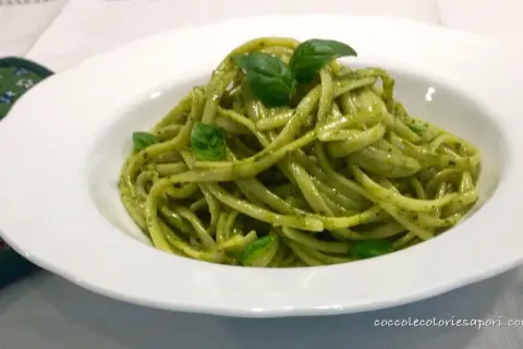 Un piatto invitante di linguine al pesto, condite con basilico fresco, pronte per essere gustate.