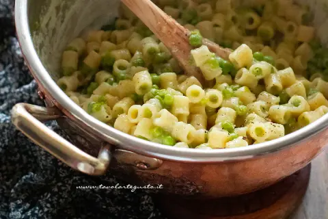 Un primo piatto cremoso di pasta e piselli, pronto per essere gustato.