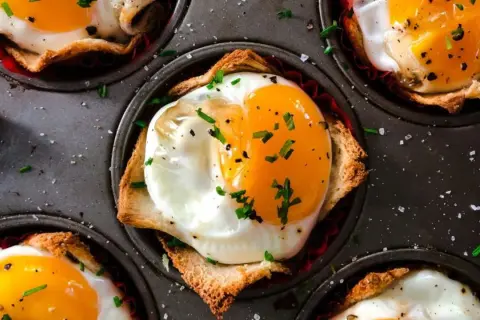 Uova al tegamino su pane tostato in stampo per muffin, un modo semplice per cucinare le uova.