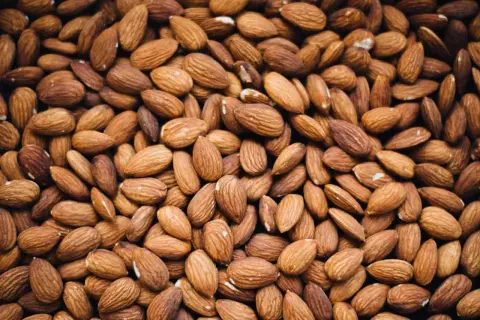 Un mucchio di mandorle, un alimento salutare ma attenzione, le mandorle fanno ingrassare se consumate in eccesso.