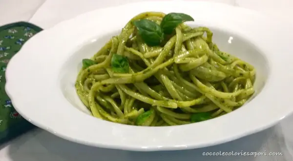 Un piatto invitante di linguine al pesto, condite con basilico fresco, pronte per essere gustate.