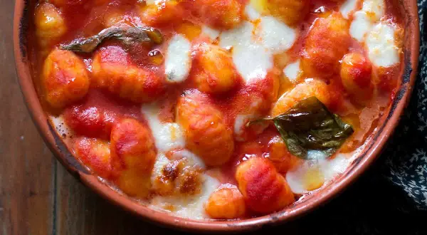 Gnocchi alla sorrentina fumanti in terracotta, con pomodoro filante e basilico fresco. Un abbraccio di sapori.