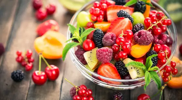 Ciotola di frutta fresca e colorata, con fragole, lamponi, ribes, more e kiwi, un'ottima scelta di frutta con meno zuccheri.