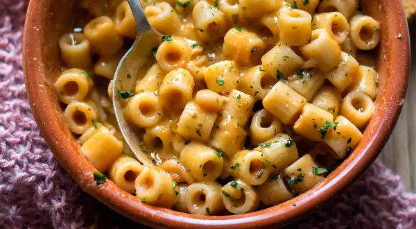Un piatto fumante di pasta e fagioli in scatola, arricchito da prezzemolo fresco, pronto per essere gustato.