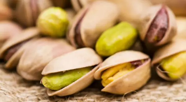 Pistacchi tostati su tela di juta. Attenzione, i pistacchi fanno ingrassare se consumati in grandi quantità!