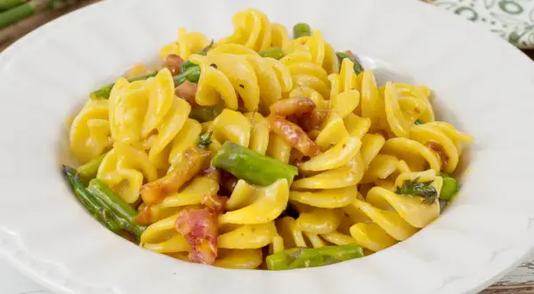Fusilli cremosi con pancetta croccante e asparagi freschi, una deliziosa carbonara di asparagi.