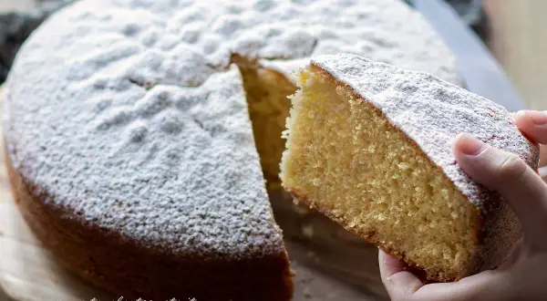Una fetta di torta Margherita, soffice e cosparsa di zucchero a velo, pronta per essere gustata. La ricetta perfetta per un dolce casalingo.