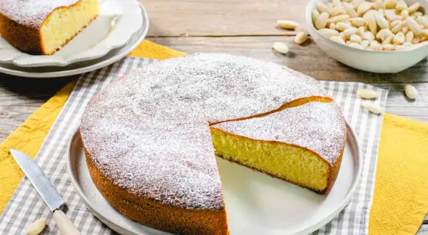 Torta soffice con farina di mandorle, spolverata di zucchero a velo, pronta per essere gustata.