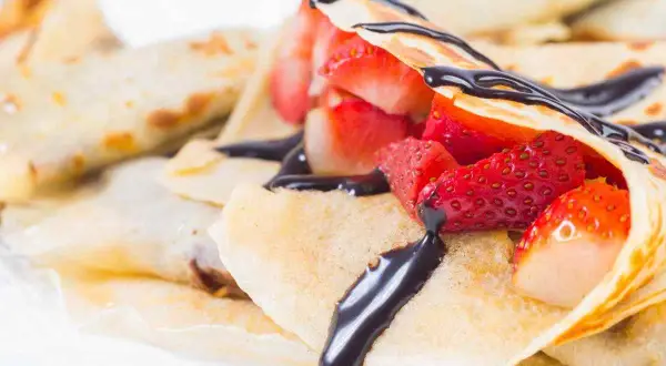 Crepes ricetta senza burro con fragole fresche e salsa al cioccolato. Deliziose e leggere, perfette per ogni occasione.