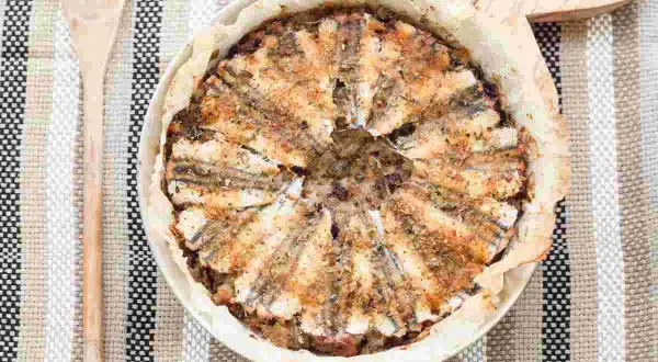 Tortiera di alici dorate e fragranti, un piatto rustico e saporito pronto per essere gustato.