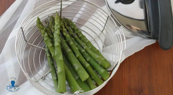 Asparagi freschi in un cestello metallico pronti per essere cotti nella pentola a pressione.