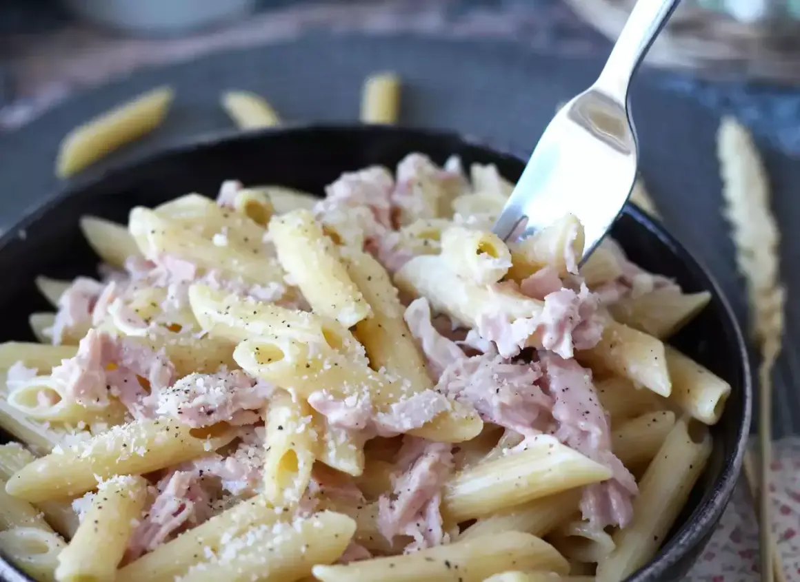 Penne cremose con prosciutto cotto e parmigiano, un piatto di pasta panna e prosciutto che invita a essere gustato.