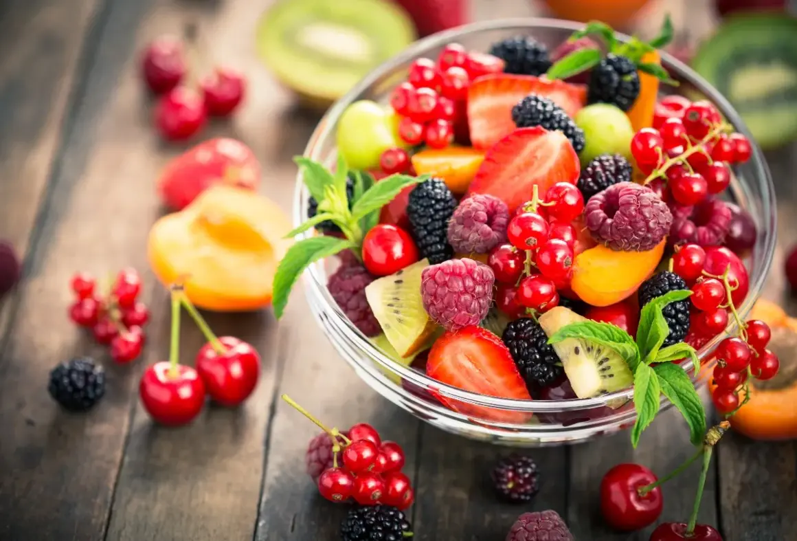 Ciotola di frutta fresca e colorata, con fragole, lamponi, ribes, more e kiwi, un'ottima scelta di frutta con meno zuccheri.