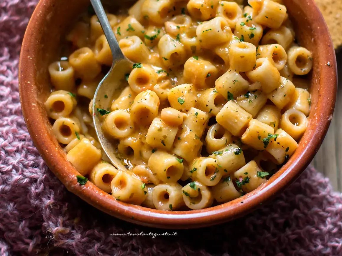 Un piatto fumante di pasta e fagioli in scatola, arricchito da prezzemolo fresco, pronto per essere gustato.