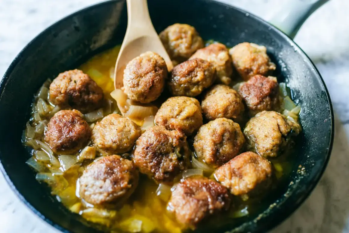 Polpette in bianco succulente in padella con cipolle caramellate, pronte per essere gustate.