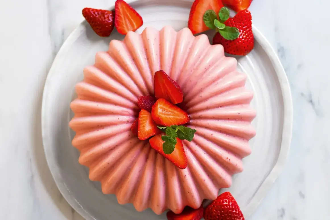 Delizioso bavarese alle fragole, decorato con fragole fresche e menta, su un piatto bianco.