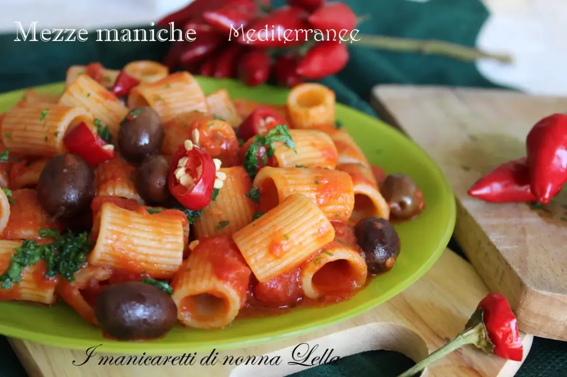 Piatto di pasta mezze maniche con pomodoro, olive e peperoncino, un classico della cucina mediterranea.