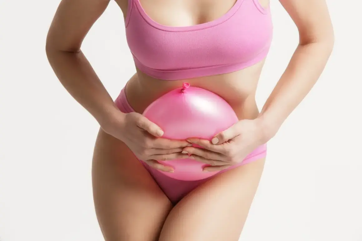 Donna con palloncino rosa sulla pancia, simbolo di gonfiore. Scopri come sgonfiare la pancia con consigli pratici.