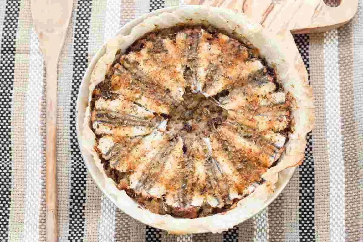 Tortiera di alici dorate e fragranti, un piatto rustico e saporito pronto per essere gustato.