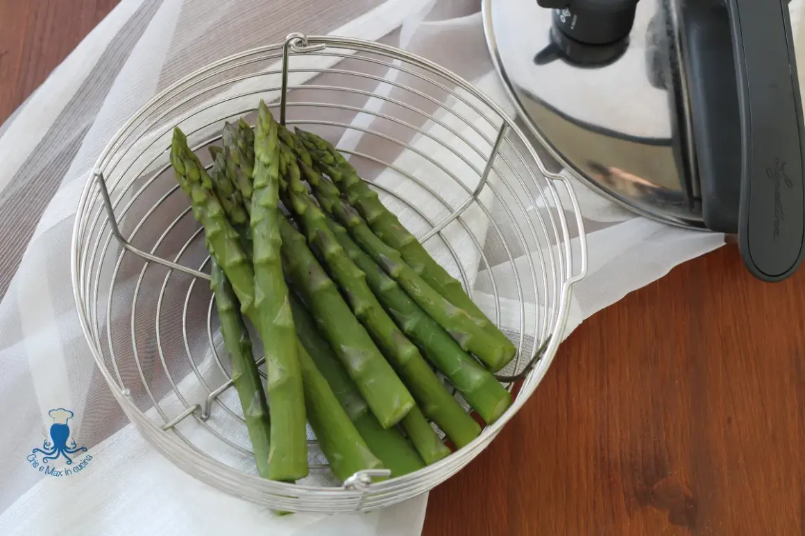 Asparagi freschi in un cestello metallico pronti per essere cotti nella pentola a pressione.