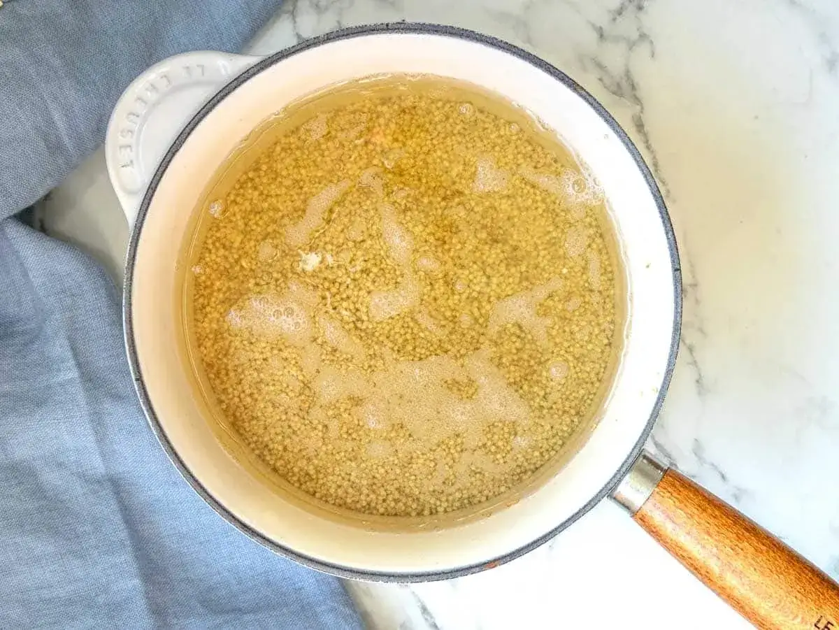 Quinoa in ebollizione in una pentola, un passo fondamentale per imparare come cuocere la quinoa perfetta.