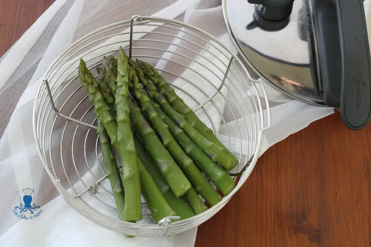 Asparagi freschi in un cestello metallico pronti per essere cotti nella pentola a pressione.