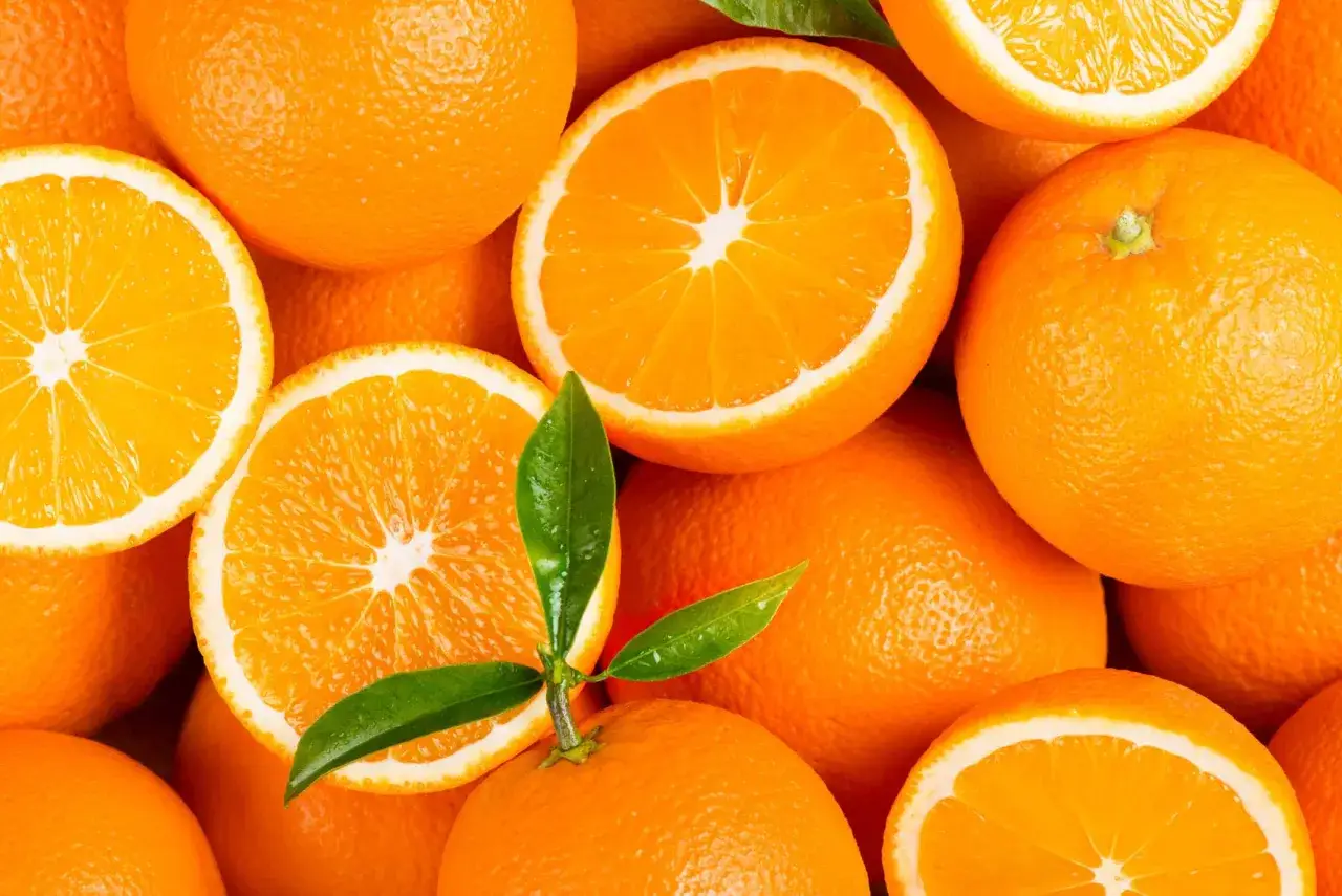 Arance fresche, intere e a fette, con foglie verdi. Quante arance si possono mangiare al giorno? Dipende, ma queste sembrano deliziose!