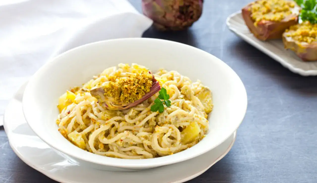 Un piatto di pasta con carciofi, un classico della cucina italiana, preparato secondo la ricetta di Cannavacciuolo.