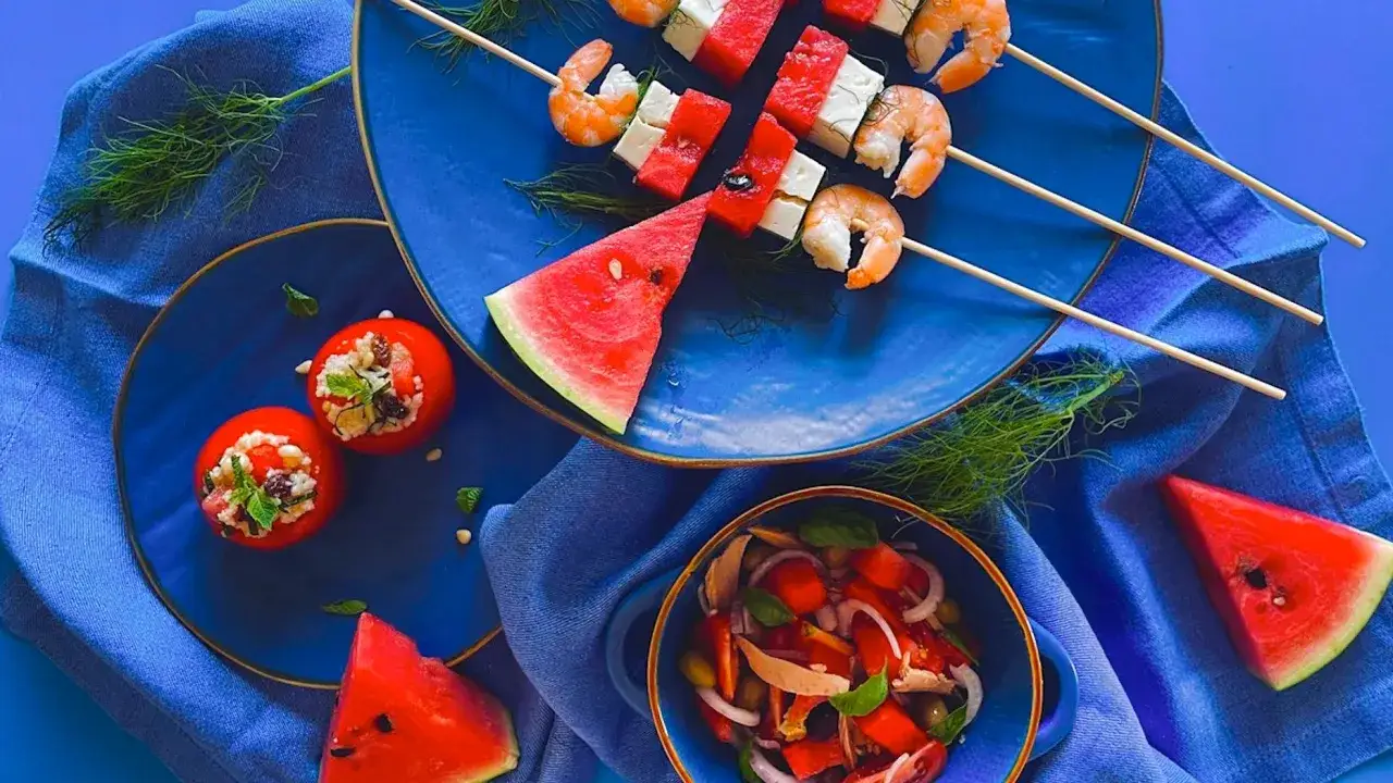 Spiedini di anguria, feta e gamberi, pomodori ripieni e insalata estiva. Un pasto fresco, ideale per chi controlla la glicemia.