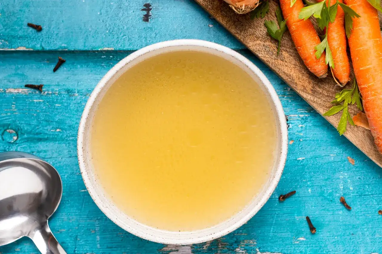 Brodo di pollo ricetta della nonna: un comfort food dorato, con carote fresche e spezie aromatiche.