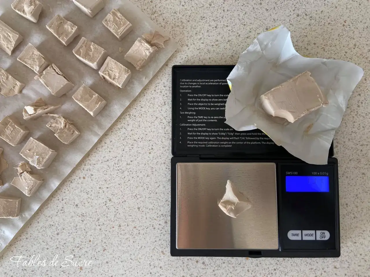 Cubetti di lievito di birra pronti per essere pesati. Un pezzo &egrave; sulla bilancia digitale, pronto per essere utilizzato per preparare deliziose ricette.
