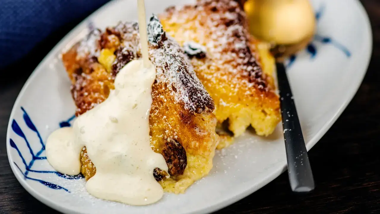 Porzioni di torta di pane dorata, cosparse di zucchero a velo, vengono innaffiate con una generosa dose di crema al mascarpone.