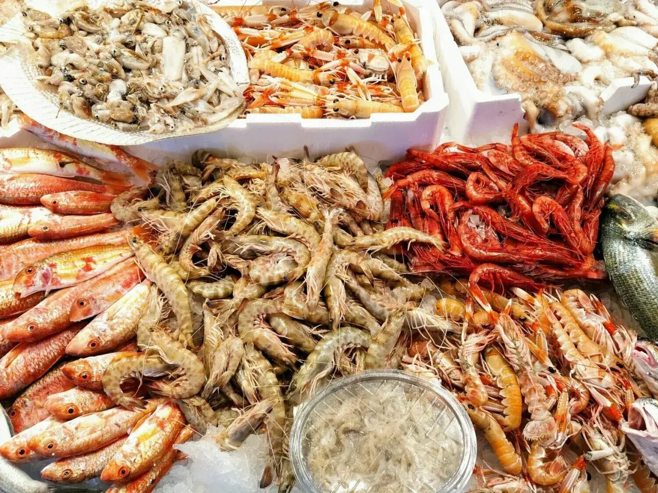 Un banco del pesce traboccante di crostacei: gamberi rossi, scampi, mazzancolle e pesci rossi. Un tripudio di sapori marini.