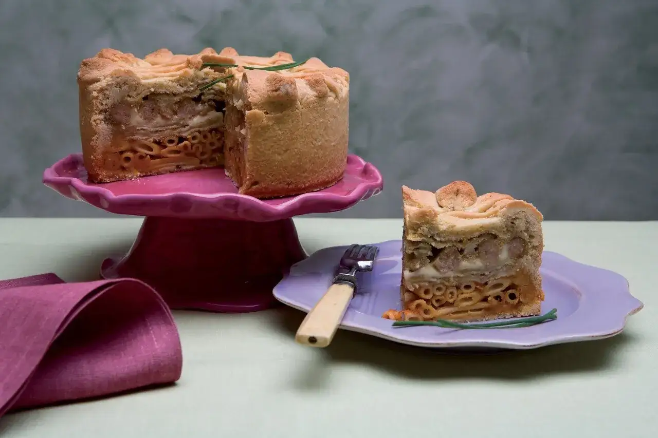 Un invitante timballo di pasta, con strati di maccheroni, salsiccia e formaggio, pronto per essere gustato.